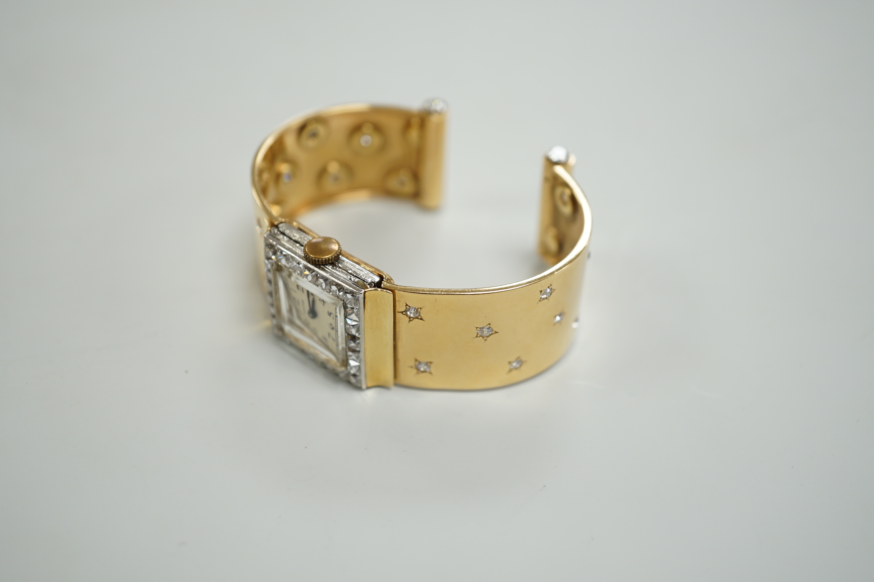 A yellow metal and diamond set Concorde manual wind open bracelet watch, with diamond set bezel and bracelet, gross weight 47.8 grams.